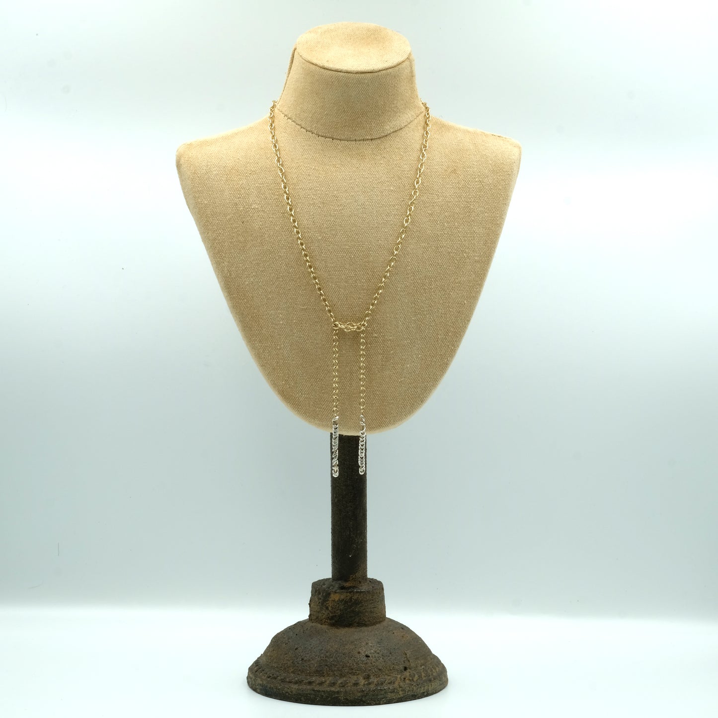 Shown on a bust to view the positioning of this flattering air loom solid gold Tie Necklace made in London by Christina Elizabeth. The length of the necklace can adapt to go closer up to your neckline. Made of solid gold wire with an element of sterling silver wire twisted round the ends. Falls beautifully and feels substantially weighty. Can be made in any combination of precious metals.