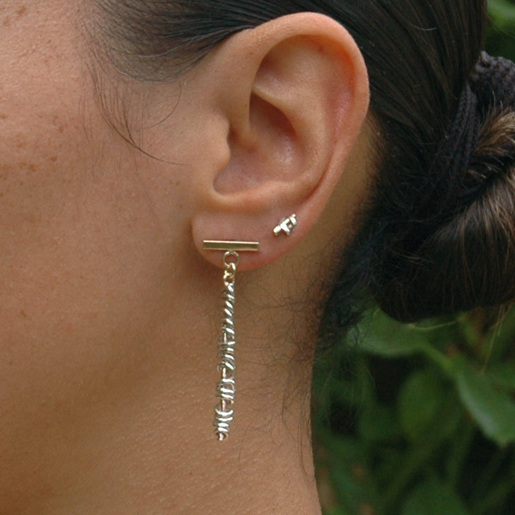 Shows The Golden Thread stud earrings on the ear to show the contest.